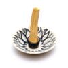 Бяла керамична поставка за изгаряне на Пало санто with a wooden stick in it.