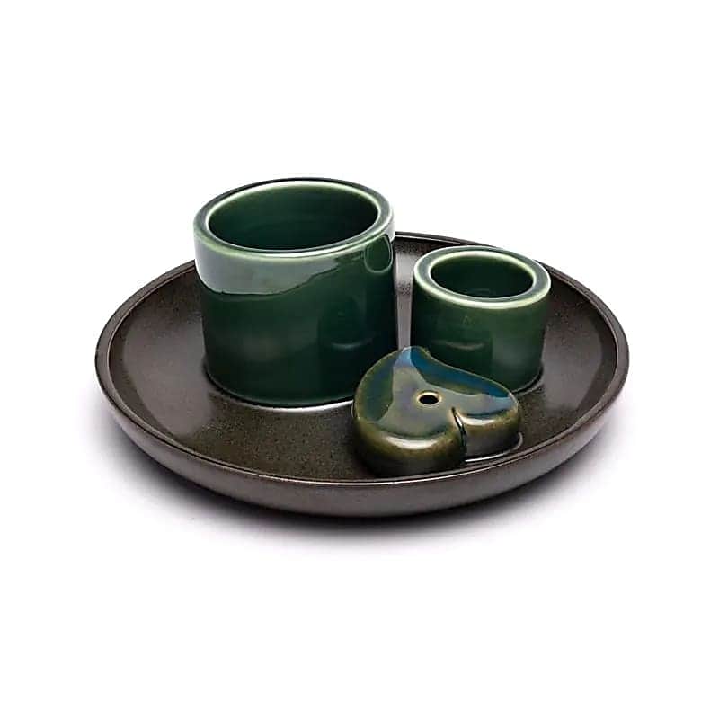 Тъмна керамична табла с надпис "Керамична поставка за Пало Санто, Бяла салвия и ароматни пръчици" с два зеленооцветени държача и зелено-кафяво керамично парче с форма на сърце и дупка.