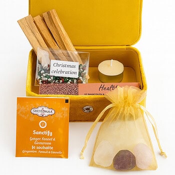 Комплект Златно слънце: жълта кутия с ароматни пръчици, чаена свещ, пакетче чай, кристали в пакетче, навит свитък и малка картичка "Коледно тържество".