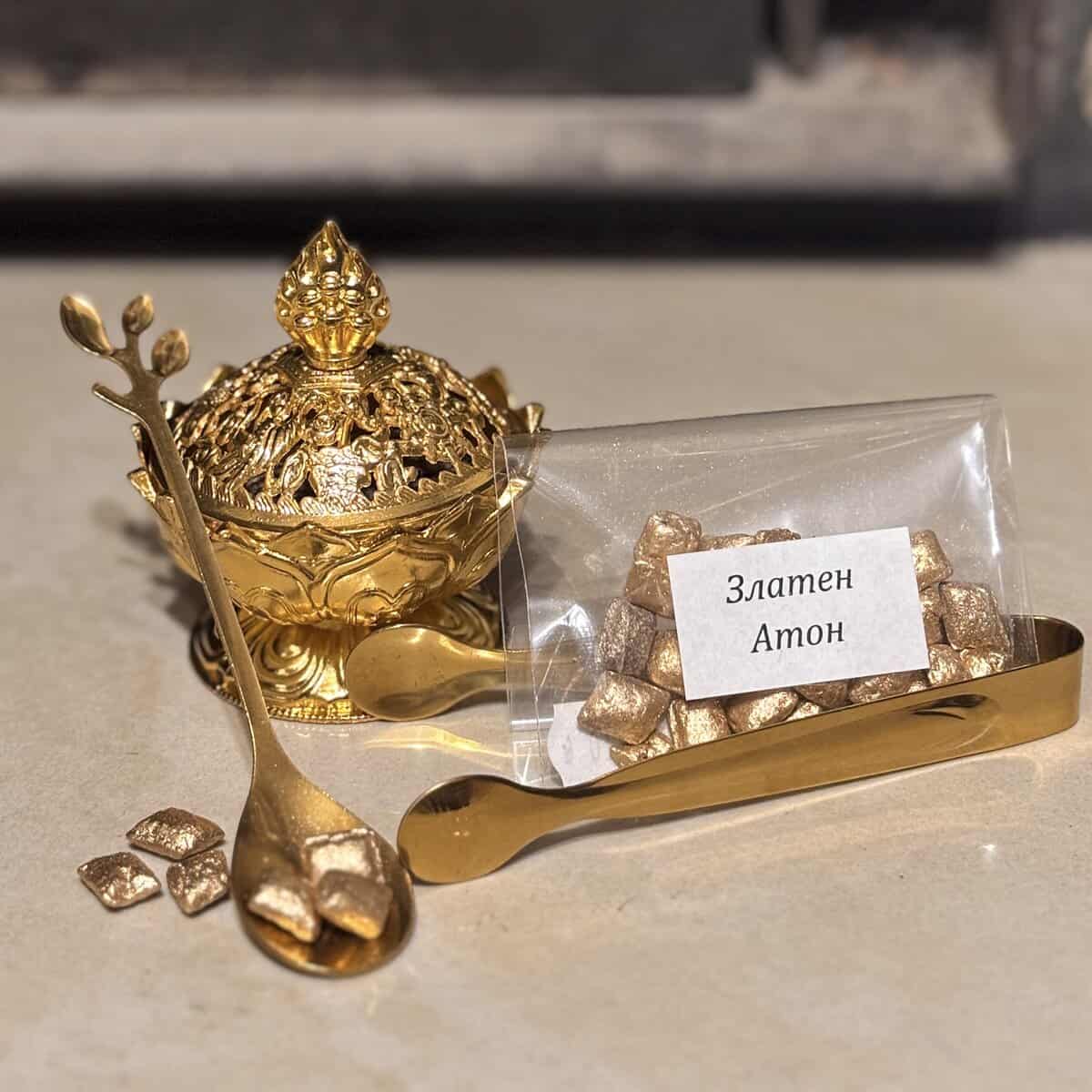 Комплектът, озаглавен "Комплект Златна Вечер", включва декоративен златен съд, лъжица, щипци и пакет с надпис "Златен Атон", пълен с бонбони в златист цвят.