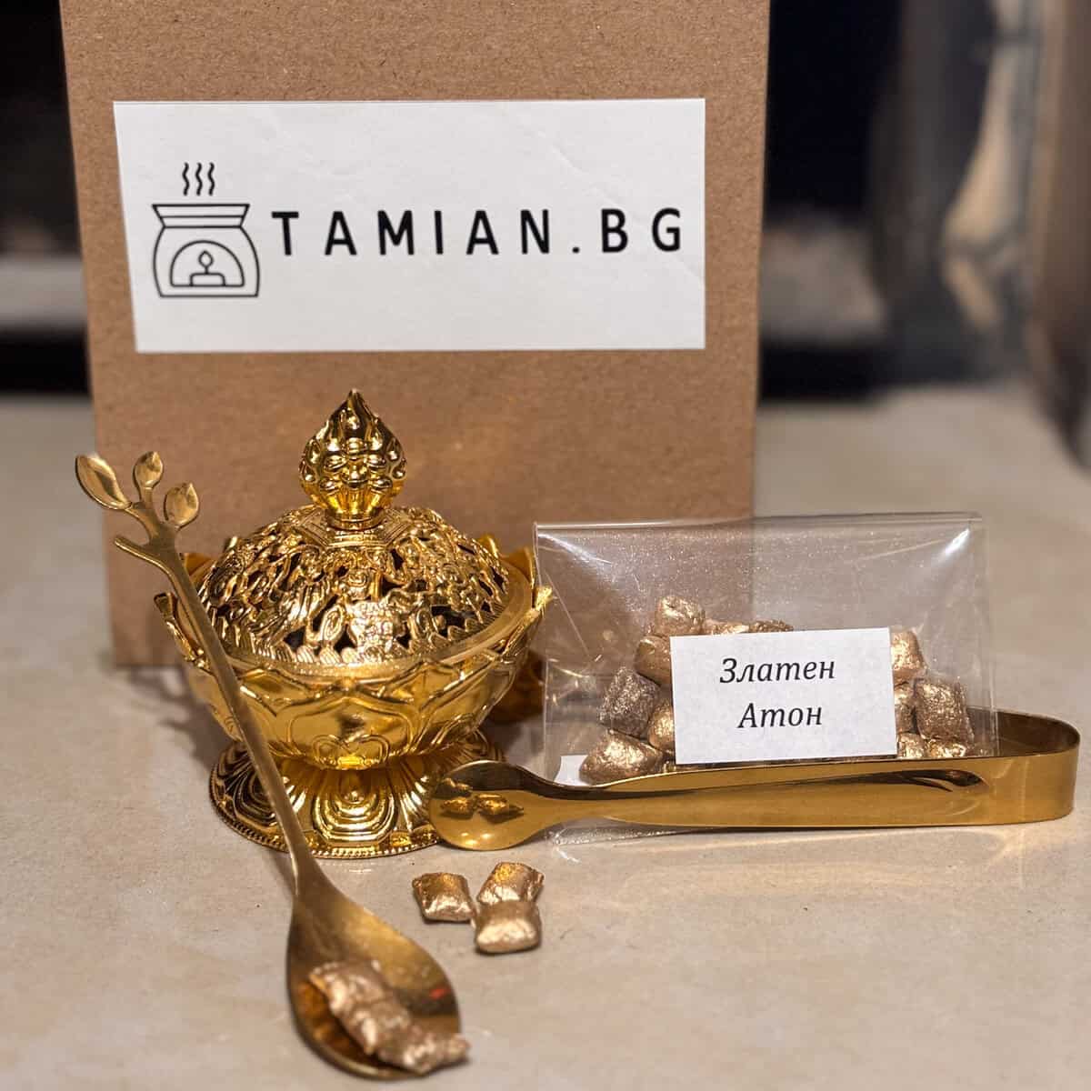 Комплект Златна Вечер" включва златна кадилница, златна лъжица, щипци и пакет "Златен Атон", изложени пред кутия с логото "TAMIAN.BG".